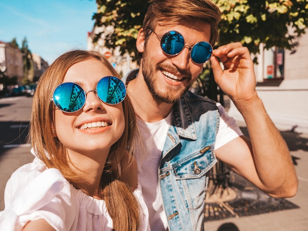 Niña hermosa sonriente y su novio guapo en ropa casual de verano.