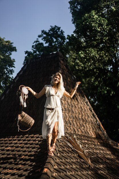 Niña india en el techo Atrapa sueños. Hermosa chica rubia con atrapasueños.