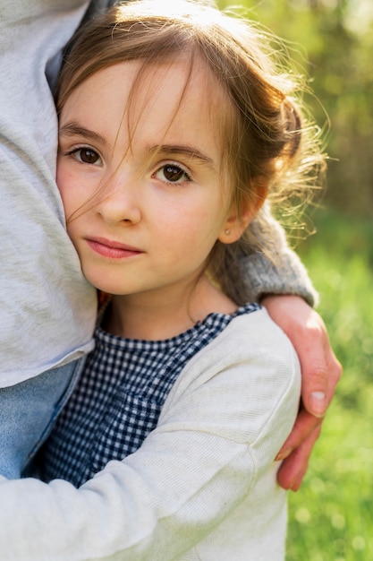 Niña inocente abrazando a la madre de cerca