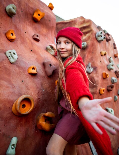 Niña intentando un muro de escalada