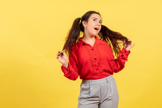 niña joven en blusa roja soñando en amarillo