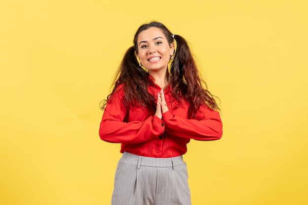 Foto gratuita niña joven, en, blusa roja, sonriente, en, amarillo