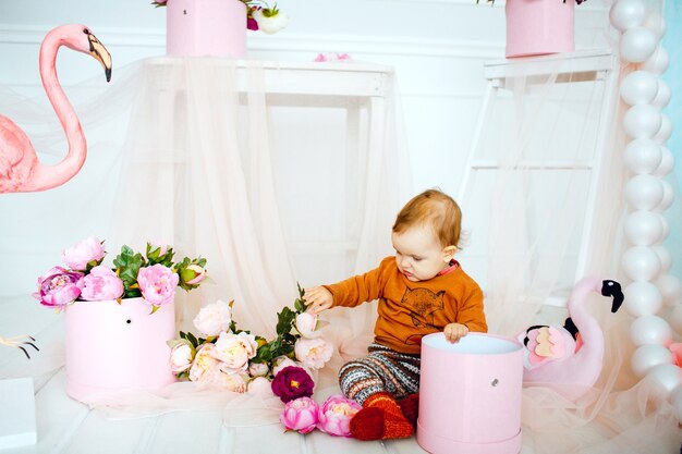 Niña juega con flores en caja rosa
