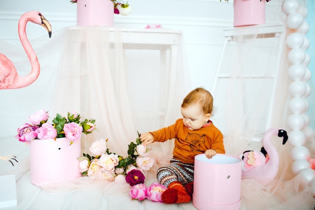 Niña juega con flores en caja rosa