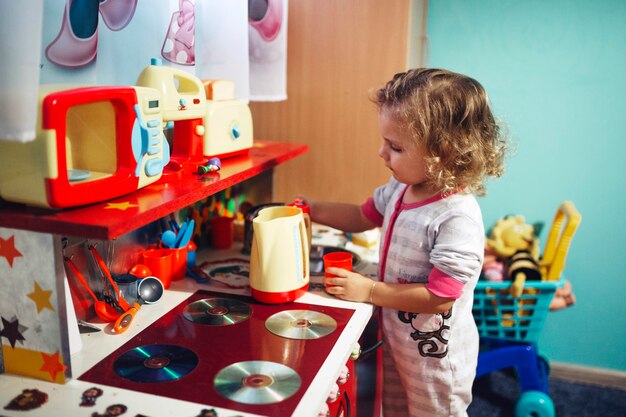 Niña jugando con cocina de juguete