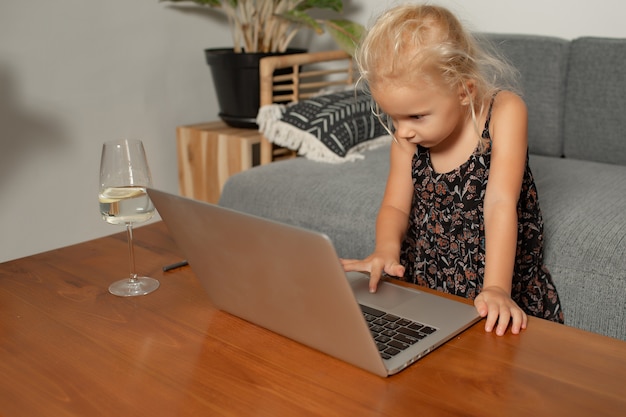 Niña jugando en la computadora portátil. Foto de alta calidad