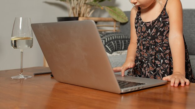 Niña jugando en la computadora portátil. Foto de alta calidad