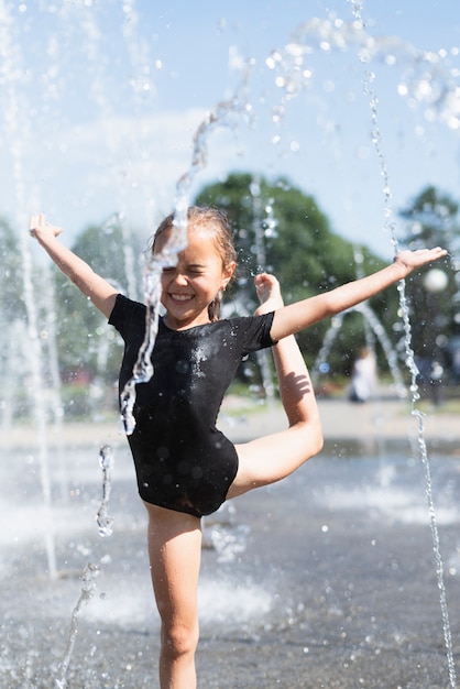 Niña jugando en la fuente de agua