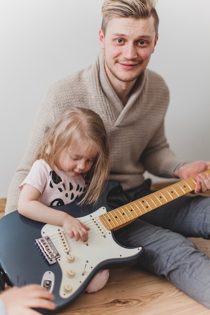 Niña jugando con la guitarra de su padre