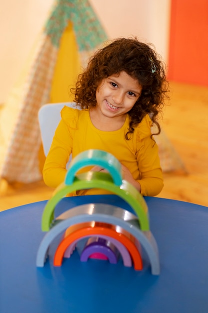 Niña jugando en el interior con juguetes ecológicos