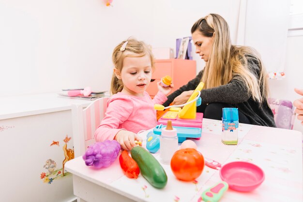 Niña jugando con juguetes en la mesa