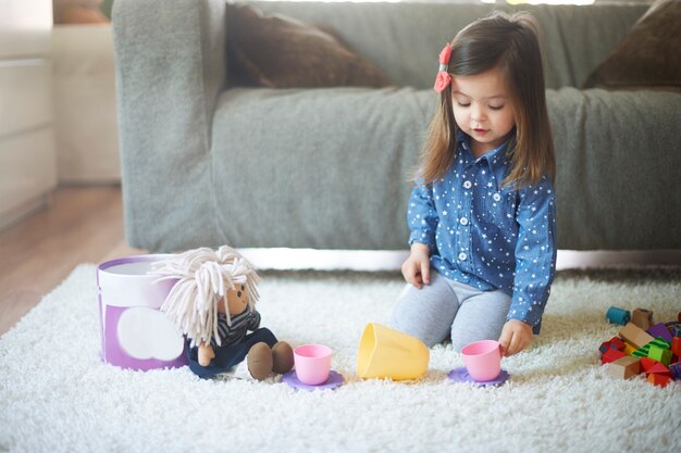 Niña jugando con juguetes en la sala de estar