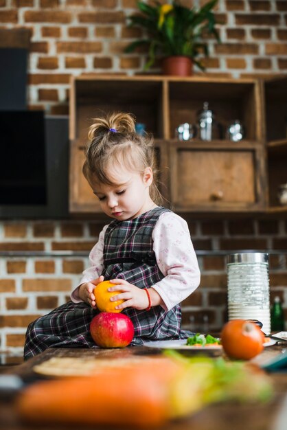 Niña jugando con manzana y limón