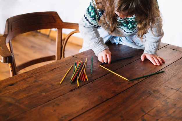 Niña jugando con palos de plástico multicolores