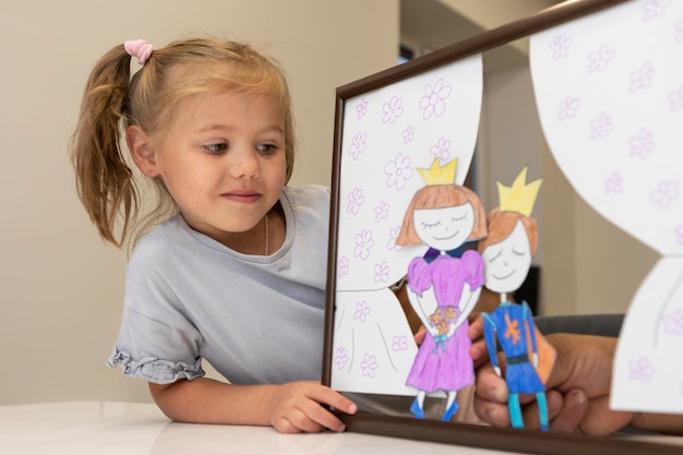 Foto gratuita niña jugando con sus títeres en casa