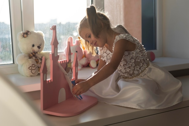 Niña jugando con títeres en casa