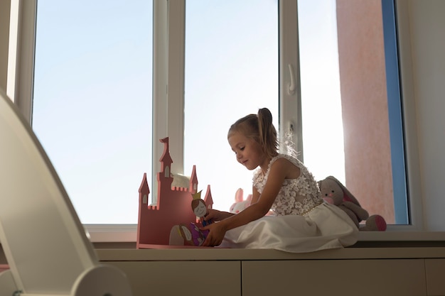 Niña jugando con títeres en casa