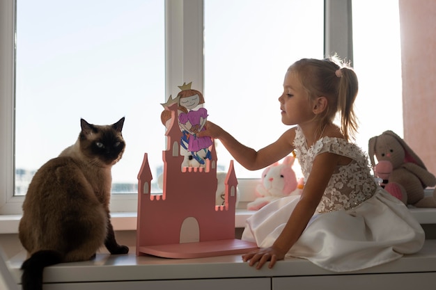 Niña jugando con títeres en casa