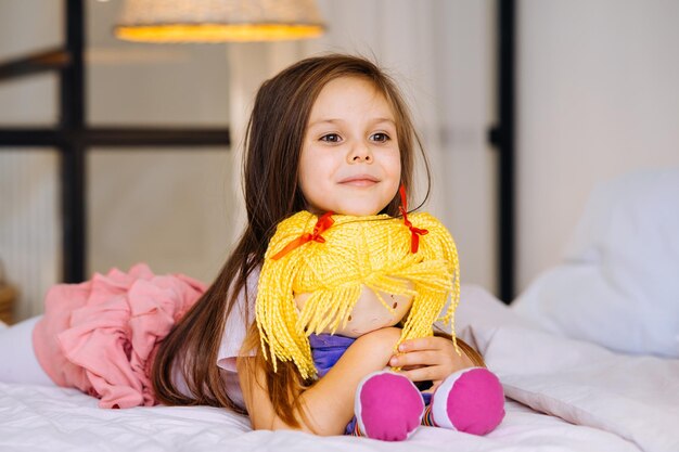 Niña con un juguete en la cama