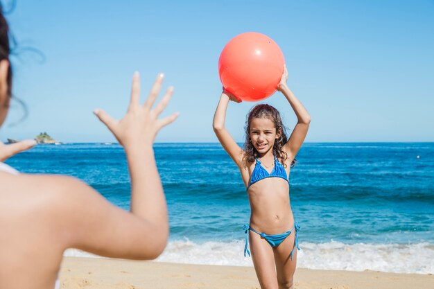 Niña lanzandole la pelota a su hermana