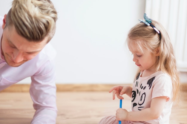 Niña con lápiz azul junto a su padre