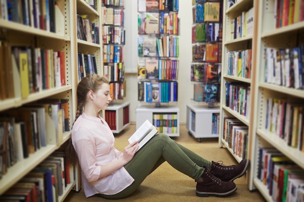 Niña leyendo en la biblioteca