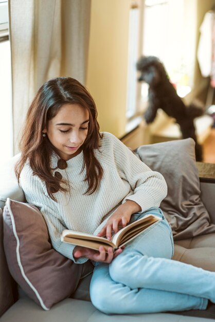 Niña leyendo en casa mientras está en cuarentena