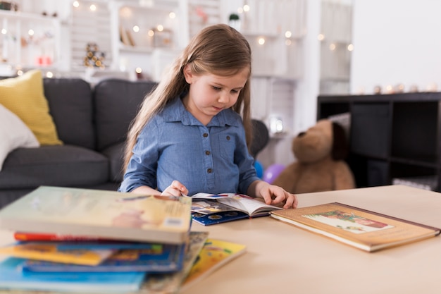 Niña leyendo libro en salón