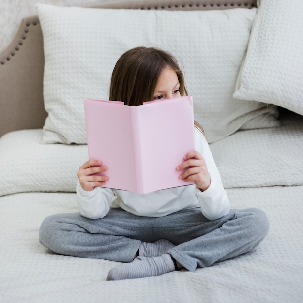 Foto gratuita niña leyendo un libro