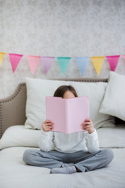 Foto gratuita niña leyendo un libro