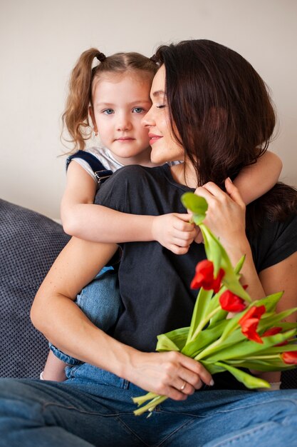 Niña linda abrazando a su hermosa madre