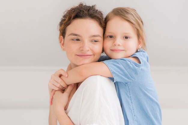 Niña linda abrazando a su madre