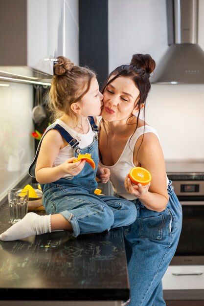 Niña linda besando a su hermosa madre