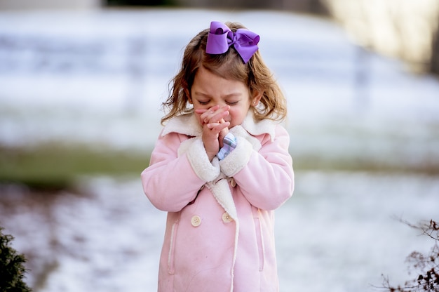 Foto gratuita niña linda con una cinta púrpura rezando en un parque