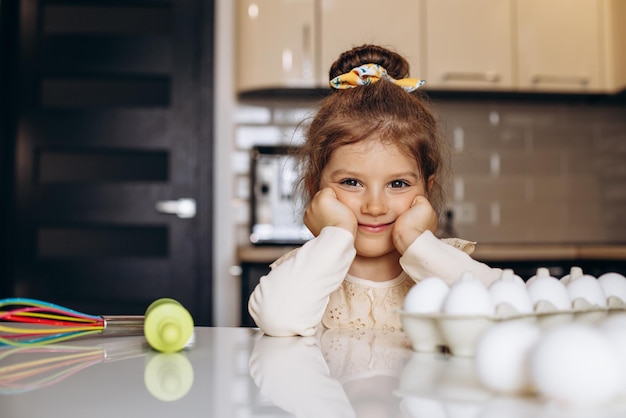 Niña linda en la cocina con rodillo