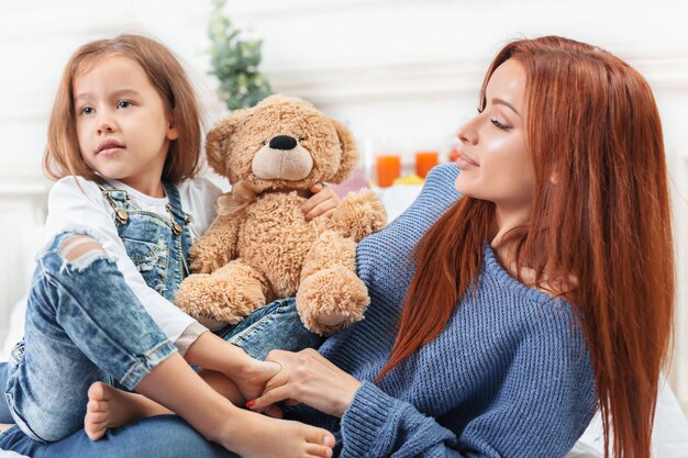 Una niña linda disfrutando, jugando y creando con juguete con madre