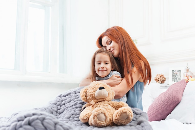 Una niña linda disfrutando, jugando y creando con juguete con madre