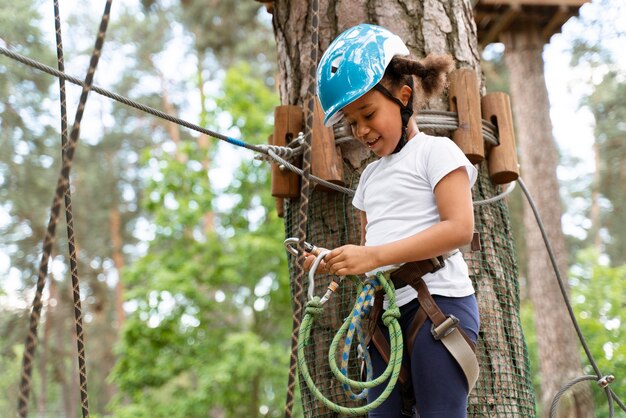 Niña linda divirtiéndose en un parque de aventuras