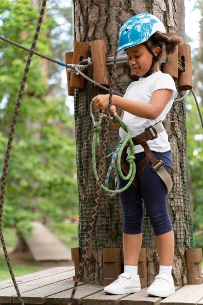 Niña linda divirtiéndose en un parque de aventuras