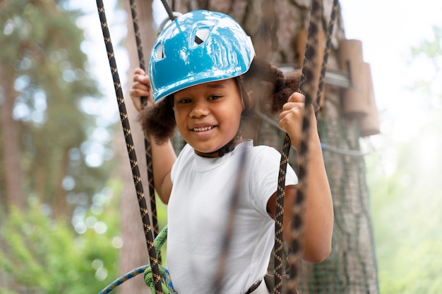 Niña linda divirtiéndose en un parque de aventuras