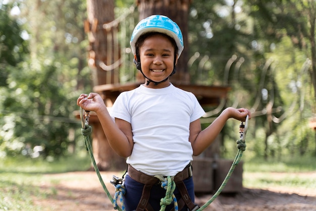 Niña linda divirtiéndose en un parque de aventuras