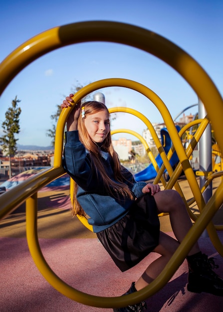 Niña linda divirtiéndose en el patio de recreo afuera