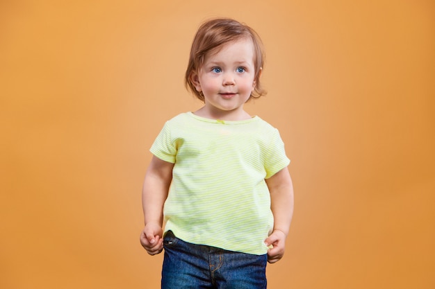 Foto gratuita una niña linda en espacio naranja