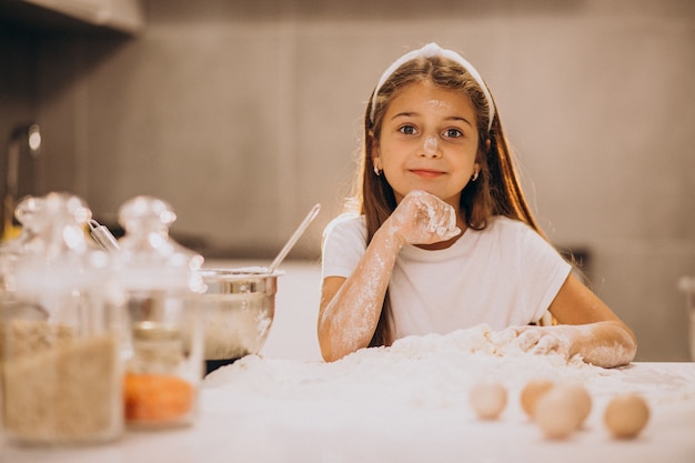 Niña linda para hornear en la cocina