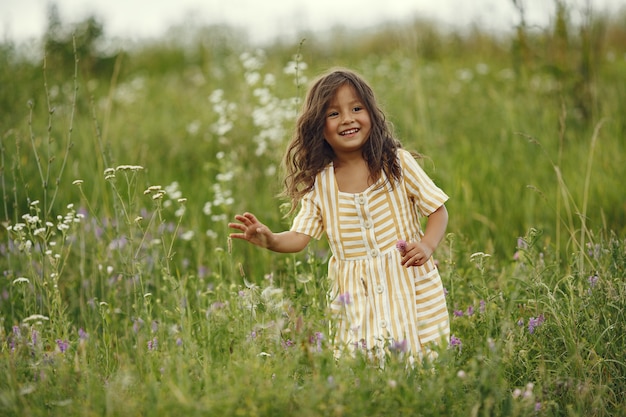 Niña linda jugando en un campo de verano