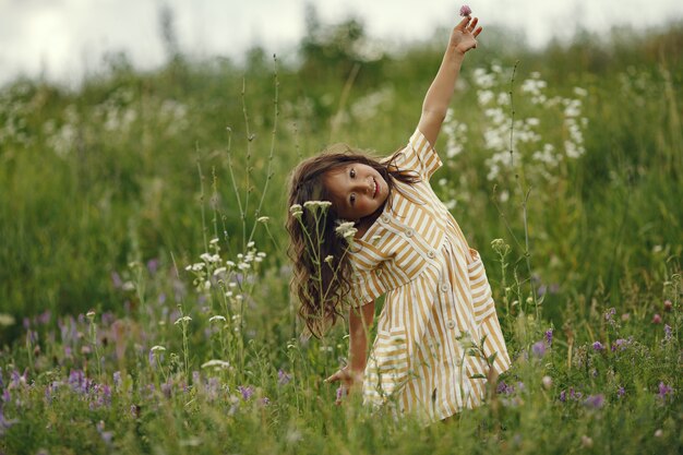 Niña linda jugando en un campo de verano