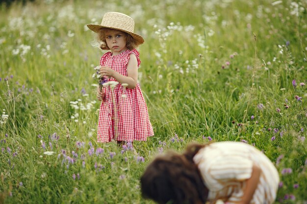 Niña linda jugando en un campo de verano