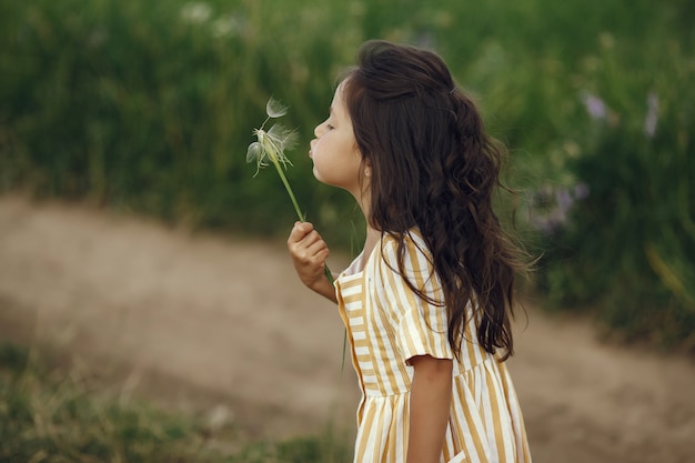 Niña linda jugando en un campo de verano