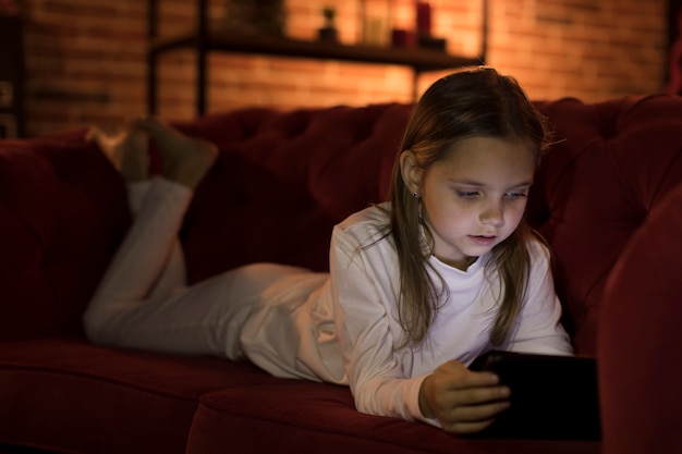 Niña linda jugando un juego en su teléfono