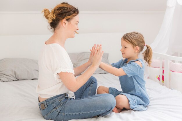 Niña linda jugando con mamá en casa